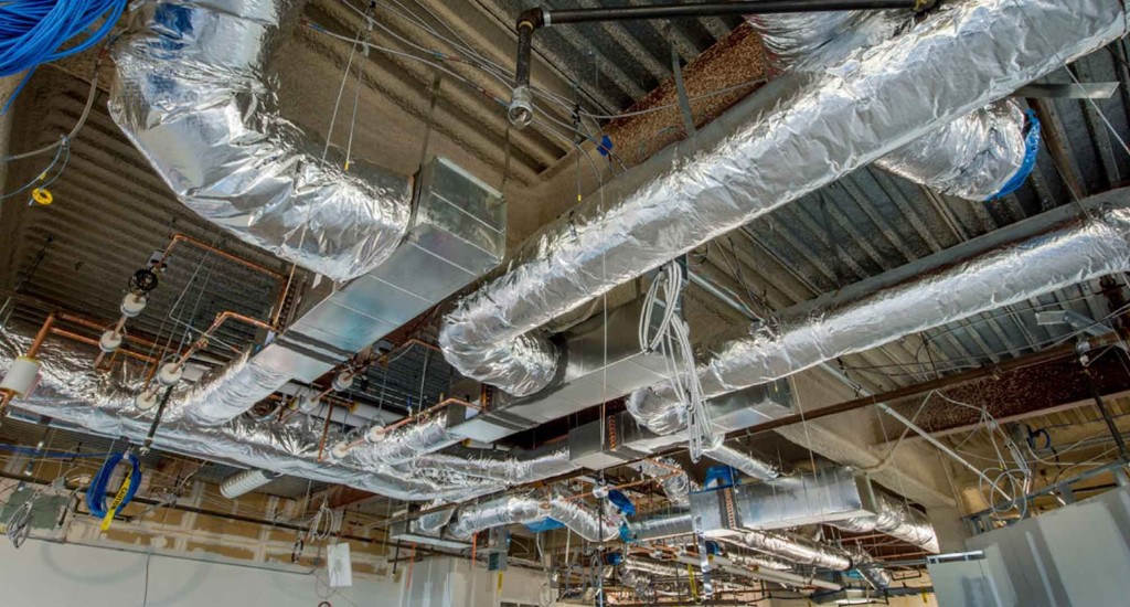 HVAC ductwork installation with insulated silver ducts